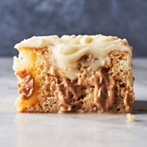 a piece of cake with gooey filling and topped with creamy filling