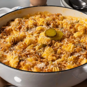 A pasta casserole with dill pickle slices on top.
