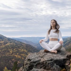 a woman on the top of a mountain meditating