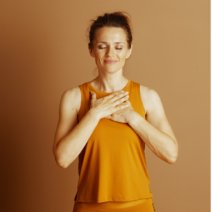 A woman with her hands on her chest with her eyes closed in a mindful manner
