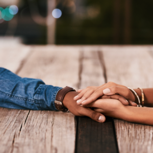 people holding hands on a wood table