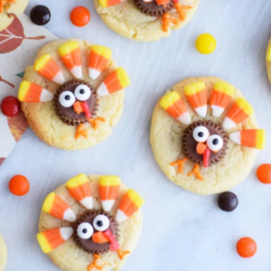 sugar cookies decorated to look like turkeys using candy corn, chocolates and frosting